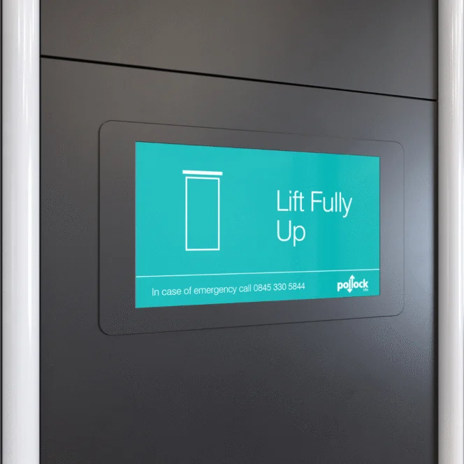 A digital display on a dark wall shows a door icon and the text "Lift Fully Up" with an emergency contact number below.