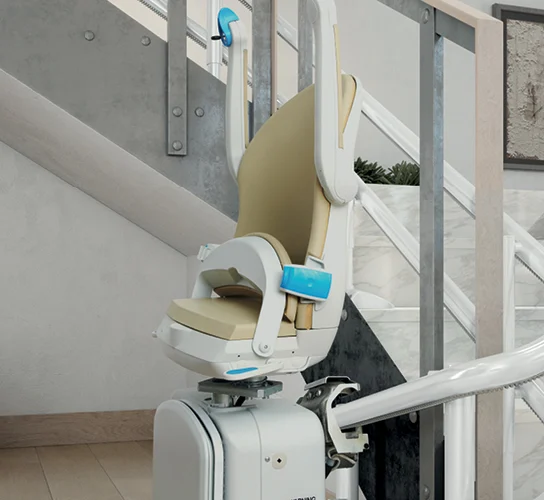 A motorized stair lift with a beige seat is installed along a curved staircase in a modern home interior.