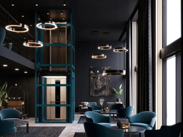 Modern lounge with teal velvet chairs, circular pendant lights, and a glass-walled elevator at the center, featuring dark walls and tall windows letting in natural light.