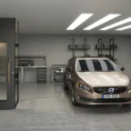A tan Volvo sedan is parked in a modern, clean garage with workbenches, tool cabinets, and overhead lighting.