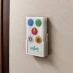 A control panel for a lift with six color-coded buttons, each featuring an icon, mounted on a light-colored wall.