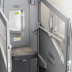 A compact private booth with a black seat, small mirror, control panel, and frosted glass partitions; suitable for privacy or work in public spaces.