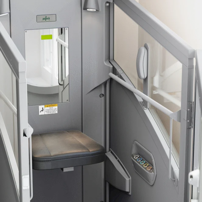 A compact private booth with a black seat, small mirror, control panel, and frosted glass partitions; suitable for privacy or work in public spaces.